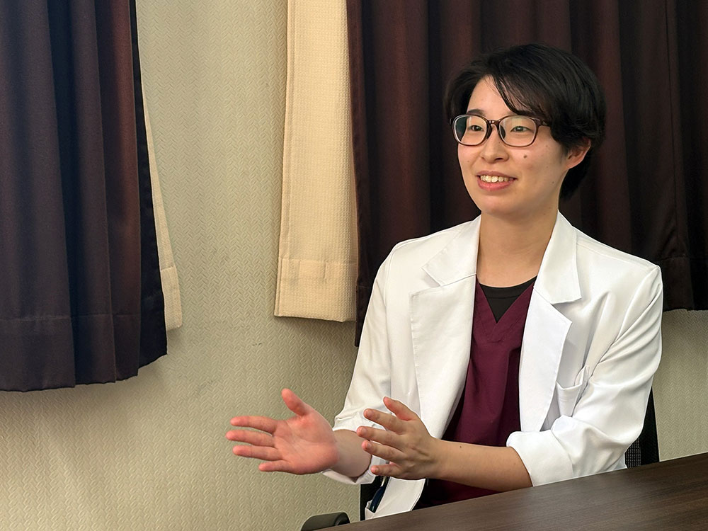 土庫病院の太田彩乃医師が身ぶりを交えてインタビューに答える様子